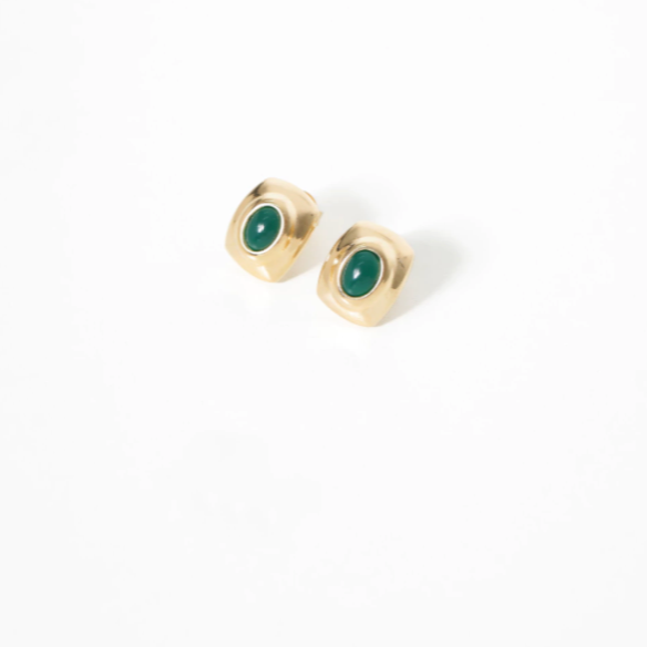 Gold earrings with green gemstones on a white background